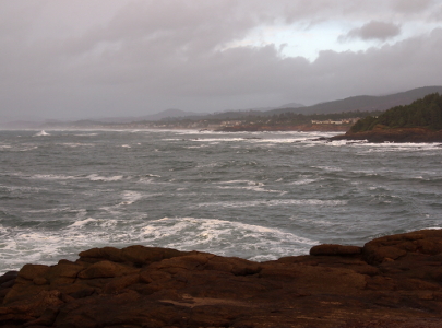 [Choppy water near the shoreline under grey clouds.]